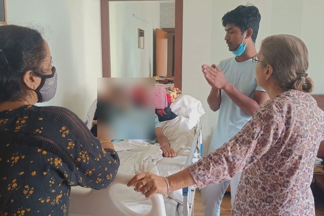 Assessment — Varolyn home care: family and caregiver discussing a patient's needs at his bedside
